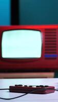 vertical Retro game console, joysticks and old tv on table playing videogames video