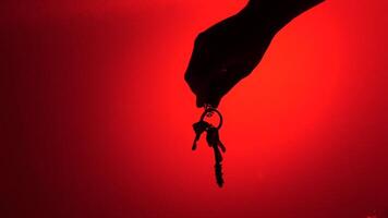 Hand holding keys on a red background video