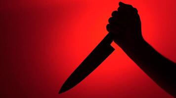 silueta de mano participación cuchillo en rojo antecedentes representando violencia video