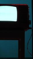 vertical Old analog television set displaying static screen in dark room video