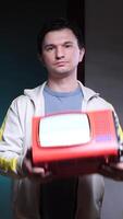Man showing throws a TV old portable television with blank screen in dark room video