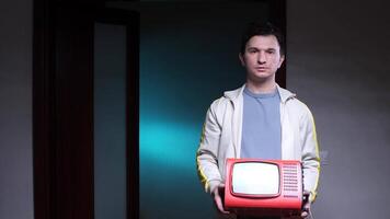 Man holding portable television set, vintage old retro red tv in dark room video