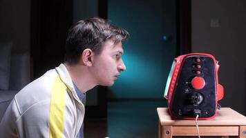 Man watching old portable red television set in dark room video