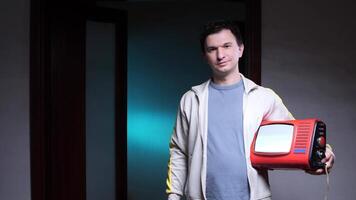 portrait Man holding portable analog television in dark room video