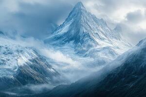 A mountain range is covered in snow and clouds photo