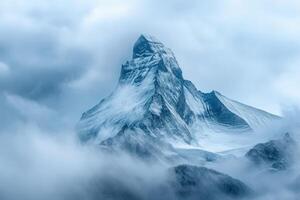 A mountain is covered in snow and clouds photo
