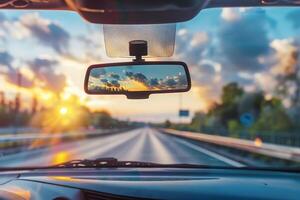 A car's rear view mirror is seen through the windshield photo