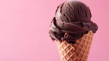 A Dark Brown ice cream cone on a pink background. Summery setting with copy space. photo