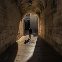 A person walking through an archway in a stone building photo