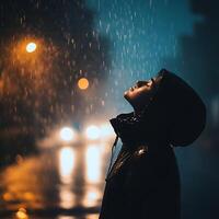 A person standing in the rain at night photo