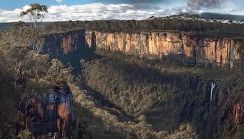 A large canyon with trees and a waterfall photo