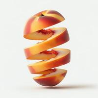 Fresh peach slices arranged with a leaf on a white backdrop. photo