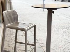Outdoor cafe setting with modern bar stool and round table photo