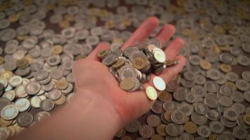 A handful of coins rests in the midst of various pieces of loose change scattered nearby video