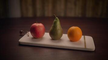 un variedad de Fresco frutas desplegado en un rústico de madera tablero manzana, pera, y naranja video