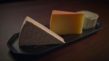 An Assorted Cheese Platter That Is Beautifully Arranged on a Dark Wooden Table Surface video