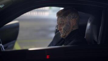 A Mysterious Figure Sitting in a Car, Adorned with Intricate and EyeCatching Tattoos video