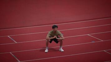 An Athlete is Performing Squats on a Running Track for Their Fitness Training Routine video