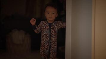 A little child dressed in cozy pajamas during a quiet night time in their home setting video