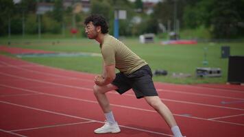 An Athlete Engaging in Stretching Exercises on a Track Field Right Before a Training Session video