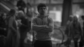 A thoughtful man stands in a busy city, reflecting on life and identity among the crowd video