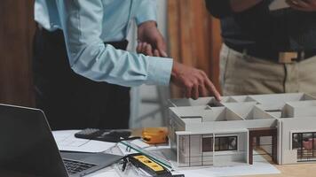 Two men are working on a model of a house video