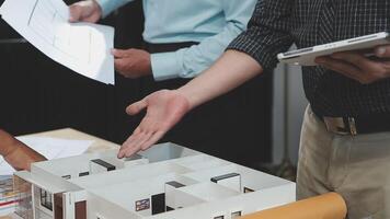 A man is shaking hands with another man over a model of a house video