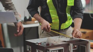 Two men are working on a model of a house video