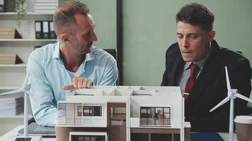 Two men looking at a model of a house video