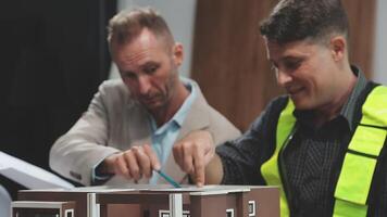 Two men working on a model of a house video