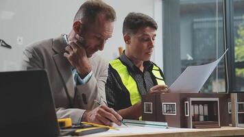 Two men working on a model of a house video