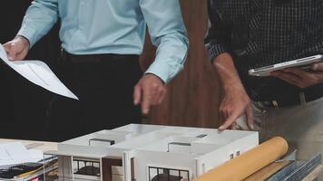 Two men are looking at a model of a house video