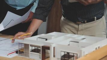 Two people looking at a model of a house video