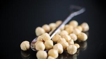 Hazelnuts in a metal spoon on a dark background video