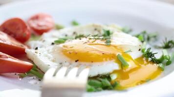 Fried eggs with cherry tomatoes and greens for breakfast. video