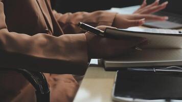 A person is writing in a notebook while sitting at a desk video