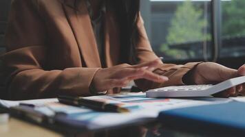 en kvinna är använder sig av en kalkylator till Beräkna de kosta av en projekt video