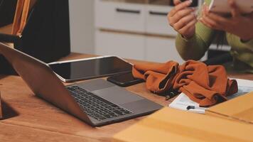 A woman is sitting at a desk with a laptop and a box video