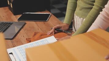 A woman is working on a laptop while holding a box video