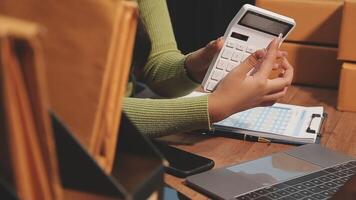 A woman is using a calculator to calculate the shipping cost video