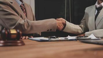 Two business people shaking hands over a desk video