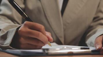 A person in a suit writing on a piece of paper video