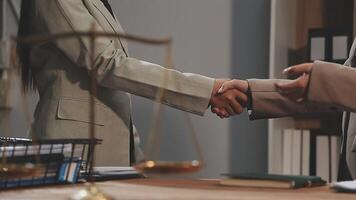 Two business people shaking hands over a desk video