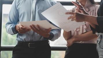 Three business people standing in front of a window video