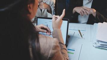 A woman is pointing at a tablet computer while sitting at a desk video