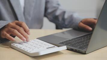 A person using a calculator on a laptop video