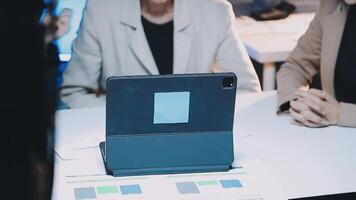 A woman is sitting at a table with a tablet computer video