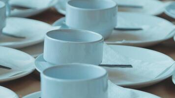 Many white cups and saucers are arranged on a table video