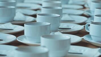 Many white cups and saucers are arranged on a table video