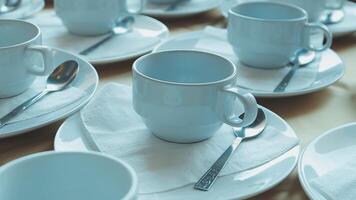 Many white cups and saucers are arranged on a table video